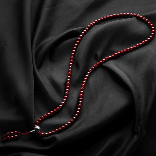 Cinnabar Mala beads on wooden surface lifestyle scene